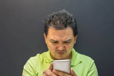 Karanlık tarzı Smartphone kullanarak Asya adam zorlanma