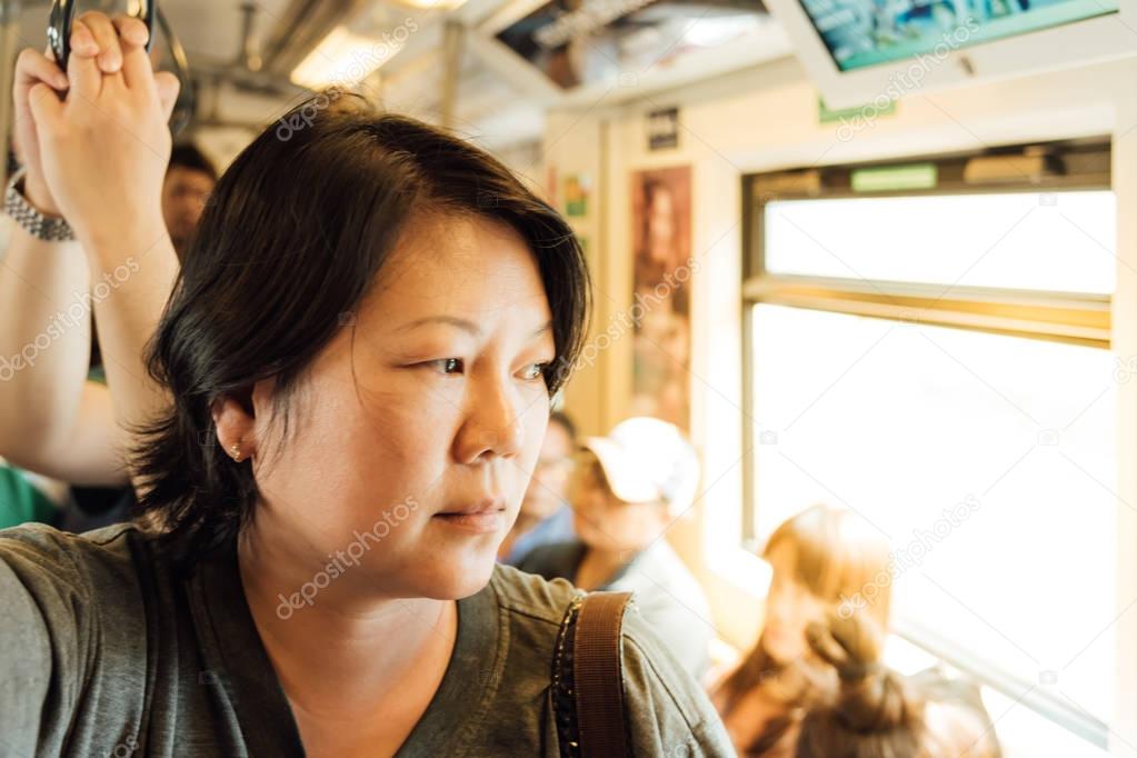 Asian woman travel on skytrain train in city