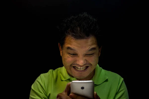Szczep azjatycki człowiek za pomocą smartfona w mrocznym klimacie — Zdjęcie stockowe
