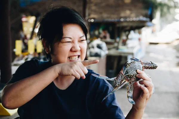 Mujer asiática y cangrejo de flores en el mercado de mariscos tailandés — Foto de Stock