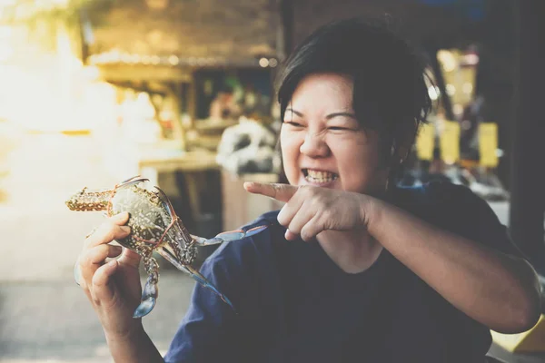 Mujer asiática y cangrejo de flores en el mercado de mariscos tailandés — Foto de Stock