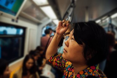 Şehirde skytrain trende Asyalı kadın seyahat