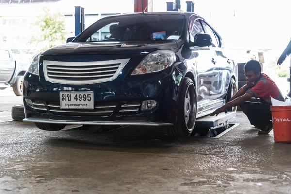 Verificação de uma suspensão de carro para reparação na garagem do carro — Fotografia de Stock