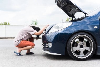 Kadın mutsuz ve kasvetli, araba motoru arızası yüzünden.