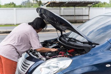 Kadın mutsuz ve kasvetli, araba motoru arızası yüzünden.