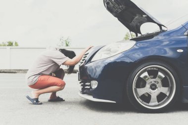 Kadın mutsuz ve kasvetli, araba motoru arızası yüzünden.