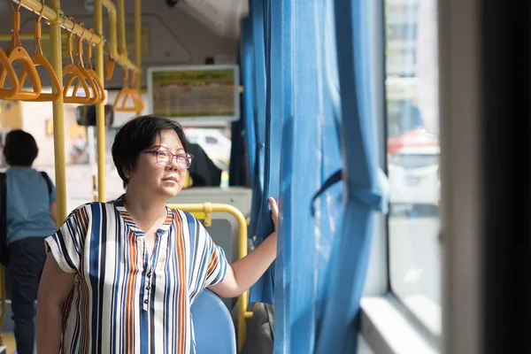 Asian woman travel by passenger bus in city