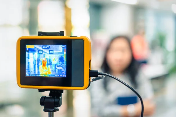 Asyalılar, Wuhan 'ın ofisinden gelen salgın gribe karşı vücut ısısını ölçmeyi bekliyor.