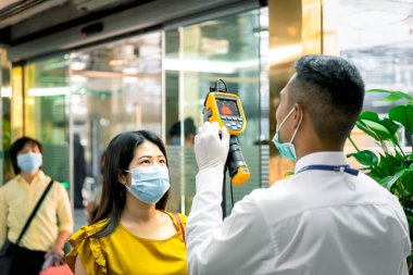 Bangkok, Thailand - March 16, 2020 : Unidentified people waiting body temperature check to access building for against epidemic flu covid19 or corona virus by thermoscan or infrared thermal camera