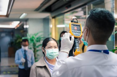 Bangkok, Thailand - March 16, 2020 : Unidentified people waiting body temperature check to access building for against epidemic flu covid19 or corona virus by thermoscan or infrared thermal camera