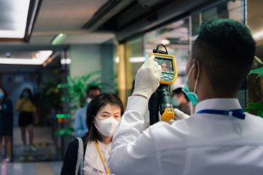 Bangkok, Thailand - March 16, 2020 : Unidentified people waiting body temperature check to access building for against epidemic flu covid19 or corona virus by thermoscan or infrared thermal camera