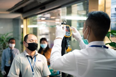 Bangkok, Thailand - March 16, 2020 : Unidentified people waiting body temperature check to access building for against epidemic flu covid19 or corona virus by thermoscan or infrared thermal camera