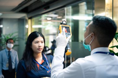 Bangkok, Thailand - March 16, 2020 : Unidentified people waiting body temperature check to access building for against epidemic flu covid19 or corona virus by thermoscan or infrared thermal camera