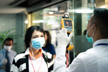 Bangkok, Thailand - March 16, 2020 : Unidentified people waiting body temperature check to access building for against epidemic flu covid19 or corona virus by thermoscan or infrared thermal camera