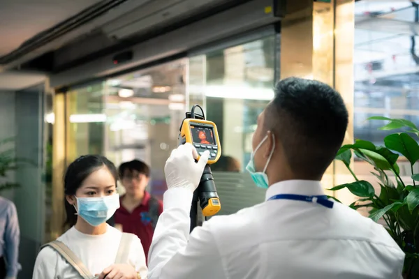Bangkok, Thailand - March 16, 2020 : Unidentified people waiting body temperature check to access building for against epidemic flu covid19 or corona virus by thermoscan or infrared thermal camera
