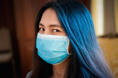 Maske takan Asyalı güzel bir kadın solunum koruma maskesi takıyor. Salgın gribe karşı. 19 yaşında ya da Wuhan 'daki Corona virüsü.