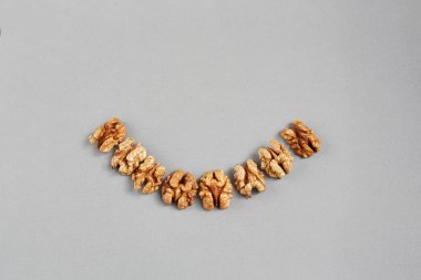 Gri arkaplandaki ceviz çekirdekleri. Gülümseme şeklinde serilmiş..