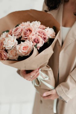 Yapay çiçekler. Bir kızın ellerinde pembe güller