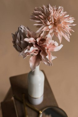 Vazonun içinde suni çiçekler var. Çiçeklerin yakın plan stüdyo fotoğrafçılığı. Dekoratif çiçekler, kendi elleriyle. Yakın planda suni çiçeklerden oluşan minimalist bir buket. Seçici odak  