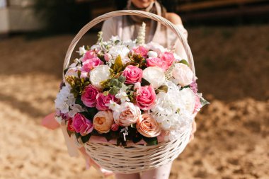 Sepetteki yapay çiçekler. Süslü çiçeklerle dolu bir sepet. Sepette buket var. Çiçek tutan çiçekçi.. 