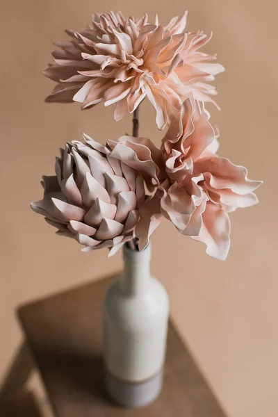 Artificial flowers in a vase close-up. Studio photography of flowers in close-up. Decorative flowers with own hands. A minimalistic bouquet of artificial flowers in close-up. Selective focus