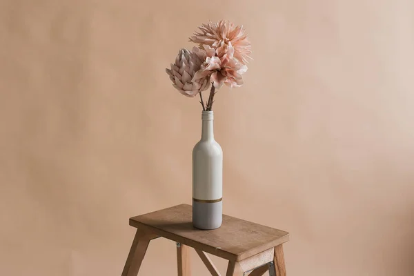 Vazodaki yapay çiçekler. Çiçeklerin stüdyo fotoğrafçılığı. Dekoratif çiçekler, kendi elleriyle. Yapay çiçeklerden oluşan minimalist bir buket 