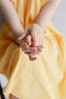 Genç bir kızın ince elleri. Sarı elbiseli kız. 