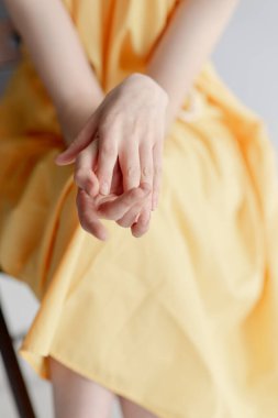 Genç bir kızın ince elleri. Sarı elbiseli kız. 