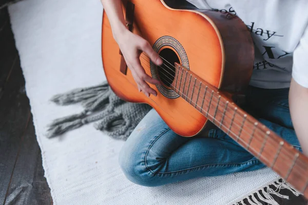 Playing the retro guitar. Girl plays guitar