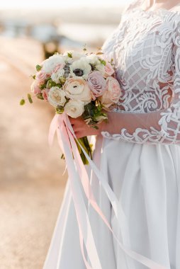 Düğün buketi gelinin elinde. Gelin bukete dokunur. Kurdeleli düğün buketi.. 