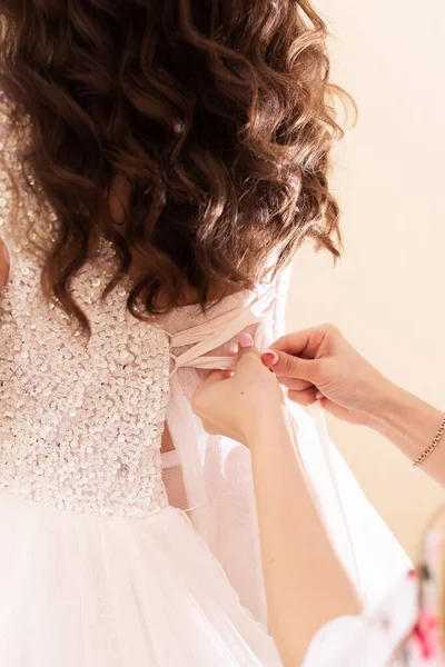花嫁をドレスで助けてください 花嫁のウェディングドレスを結ぶために 彼女は花嫁を助ける — ストック写真