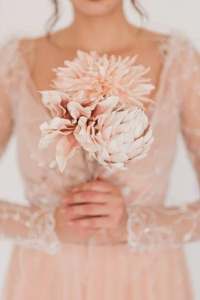 Artificial flowers in a vase close-up. Studio photography of flowers in close-up. Decorative flowers with own hands. A minimalistic bouquet of artificial flowers in close-up. Selective focus