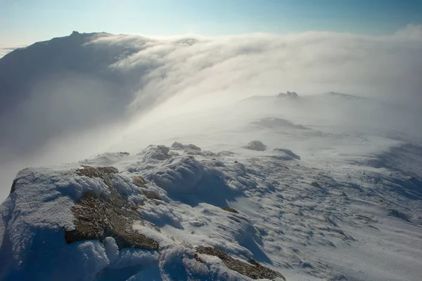 Скала, покрытая снегом и туманом — стоковое фото