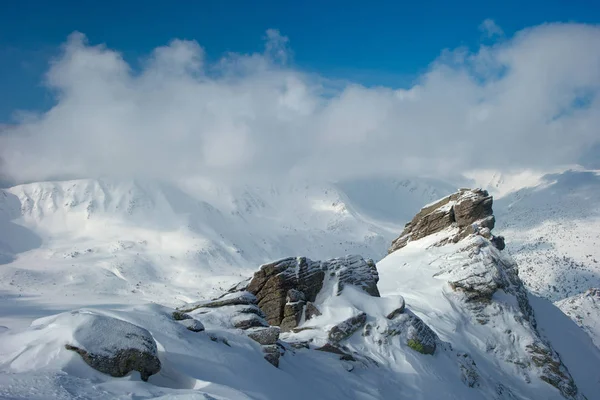 Rock bedekt met sneeuw en mist — Stockfoto
