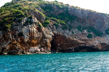 Alanya 'nın okyanus tarafından küçük kayalık bir dağ. Hangi ağaçların üzerinde yoğun olarak yer almadığını. Ayrıca kayalıkların derinliklerine doğru uzanan bir vadi var. Tüm manzara mavi su tarafından vurgulanıyor.