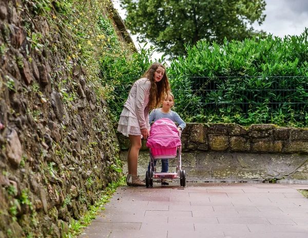 Deux sœurs avec porte-bébé pour poupées — Photo