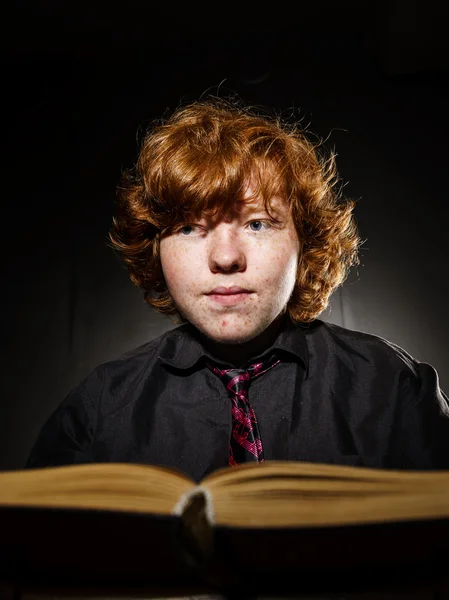 Freckled red-haired teenage boy reading book, education concept — Stock Photo, Image