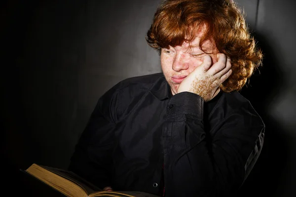 Freckled red-haired teenage boy reading book, education concept — Stock Photo, Image