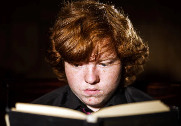 Rêve rousse adolescent garçon aux cheveux roux lecture livre, concept éducatif — Photo