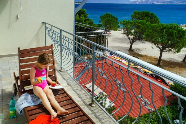 Милая маленькая девочка загорает на балконе у моря — стоковое фото