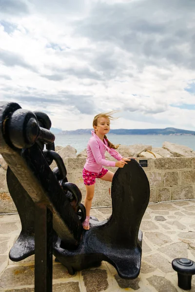 Cute little girl with ship anchor on the seaside — Stock Photo, Image