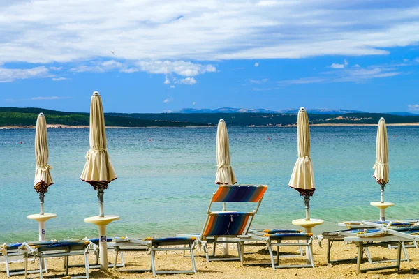 Пустой морской пляж с закрытыми солнечными зонтиками, Хорватия, ливень — стоковое фото