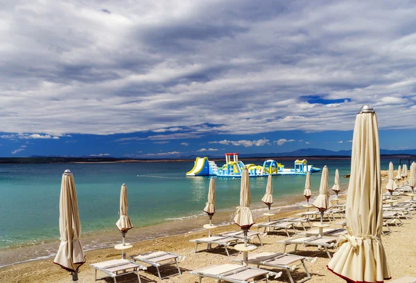Empty sea beach with closed sun-umbrellas, Croatia, stormy weath — Stock Photo, Image