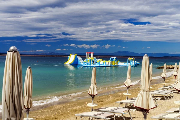 Leerer Meeresstrand mit geschlossenen Sonnenschirmen, Kroatien, stürmisches Wetter — Stockfoto