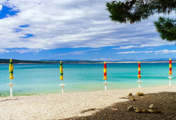 Playa de mar vacía con sombrillas cerradas, Croacia, terreno tormentoso — Foto de Stock