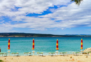 Boş deniz plaj kapalı şemsiyeleri Hırvatistan, fırtınalı hava weath ile