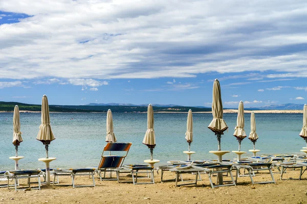 Leerer Meeresstrand mit geschlossenen Sonnenschirmen, Kroatien, stürmisches Wetter — Stockfoto