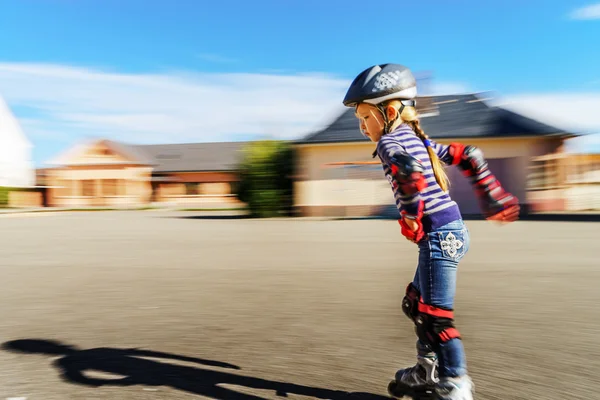 Schattig klein meisje leren rollering in het park — Stockfoto