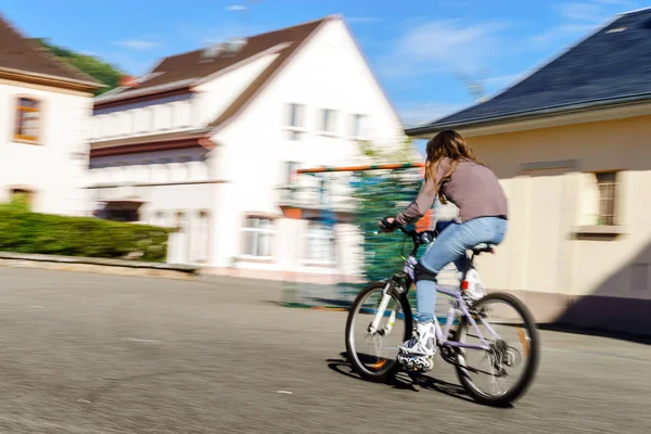 Adolescente bicyclette en bottes à roulettes. Vitesse de tir — Photo