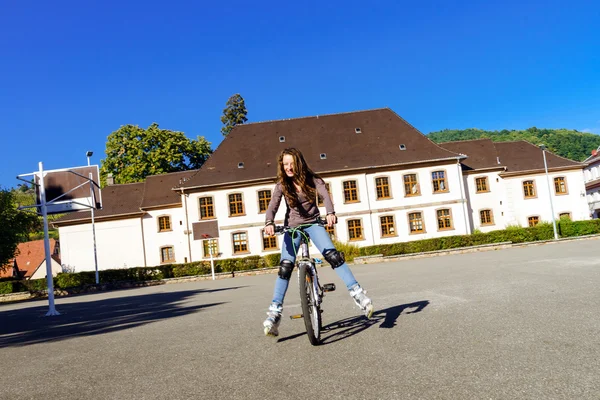 Dospívající dívka na kole v kolečkové boty. Rychlost střelby — Stock fotografie